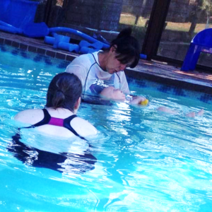 Teaching a baby how to swim with the mom in the pool