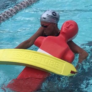 Lifesaver carrying a manikin in the pool