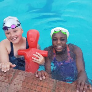 2 JLA lifeguards in the pool holding a manikin