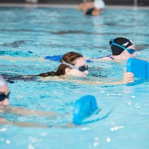 Adults swimming with kickboards